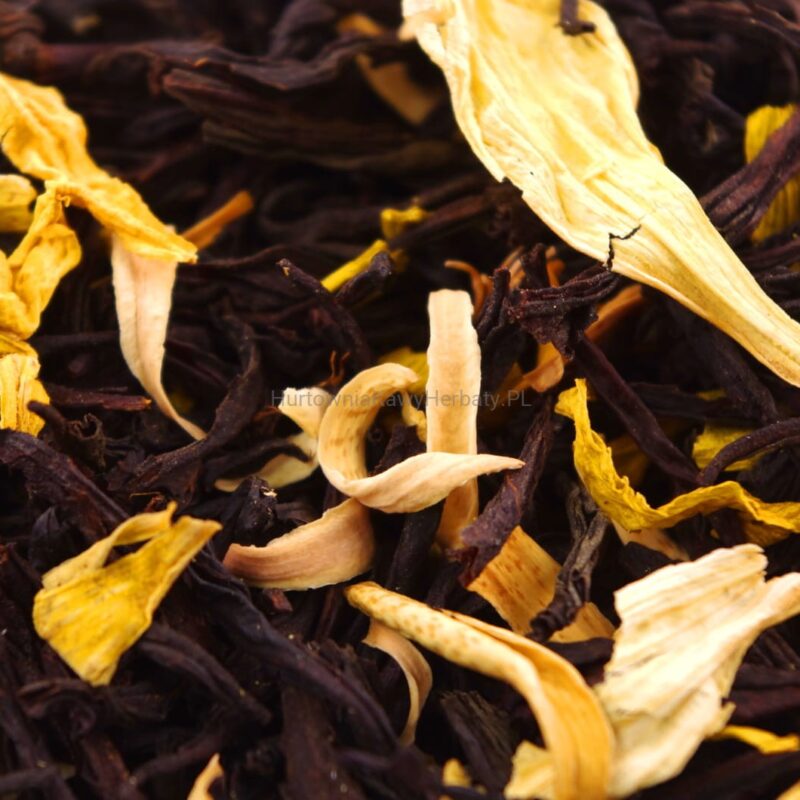 Zbliżenie na stos czarnych i żółtych liści herbaty, ukazujące ich teksturę i kolorystykę.